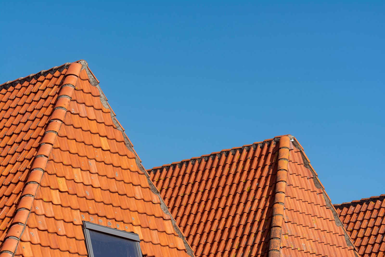 Platzhalter: Dachziegel gegen blauen Himmel, gekauftes Symbolbild